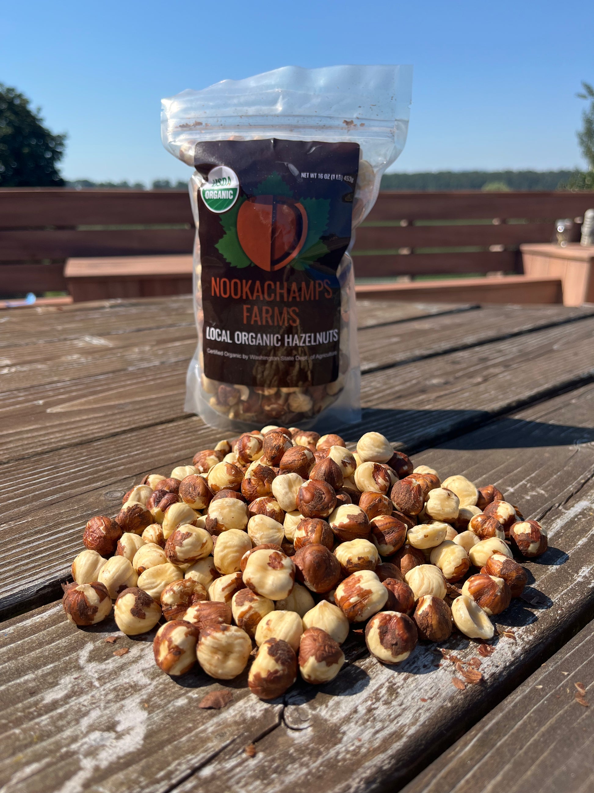 Hazelnut package with unpackaged hazelnuts in front of it